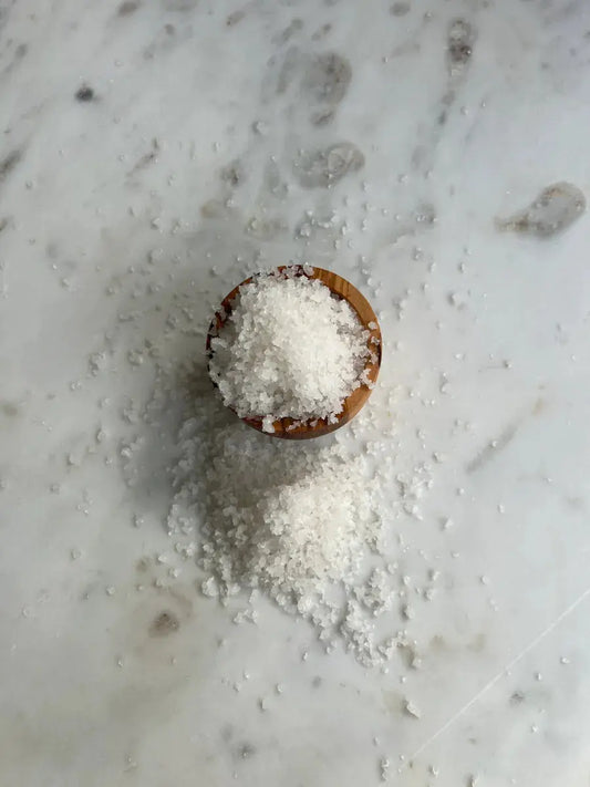 Open glass jar coarse Sicilian sea salt ready for cooking